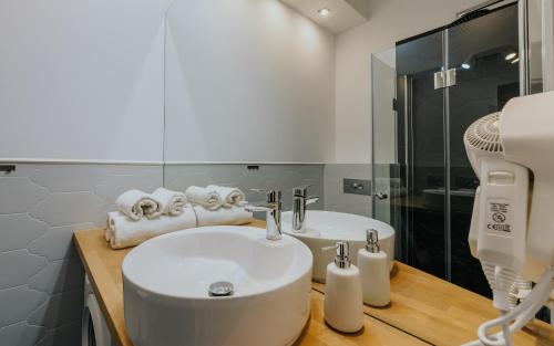 a white bathroom with a sink and a shower at Stare Kasyno Aparthotel in Wrocław