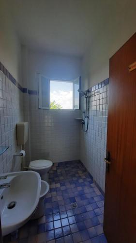a bathroom with a sink and a toilet and a window at Albergo Rita in Rimini