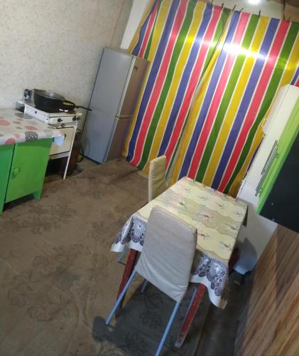 eine Küche mit einem Tisch und Stühlen sowie einem Kühlschrank in der Unterkunft Дача посуточно Балхаш in Balqasch