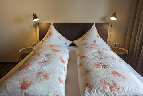 2 cuscini posti sopra un letto di Apartments Fischerklause am Bodensee a Wasserburg