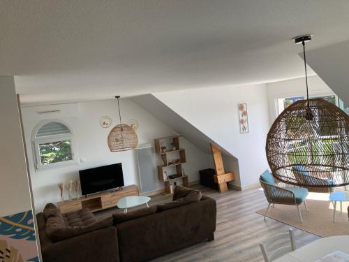 een woonkamer met een bank en een tv bij Grand appartement lumineux 4 pers. / vue mer / Wifi inclus in Quiberon