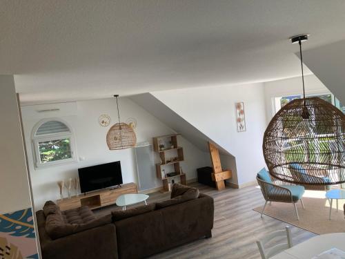 a living room with a couch and a tv at Grand appartement lumineux 4 pers. / vue mer / Wifi inclus in Quiberon