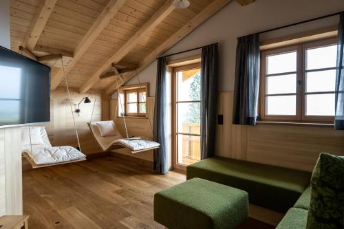 a living room with swing chairs and a tv at Waldchalets & Ferienwohnungen Allgäu in Burgberg