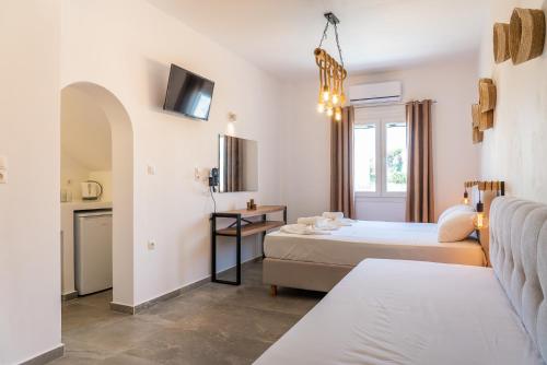 una camera d'albergo con due letti e un divano di Eleftheria Studios a Città di Antiparo