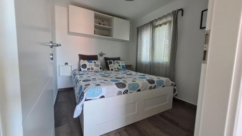 niewielka biała sypialnia z łóżkiem i oknem w obiekcie Apartman Dado w mieście Cres