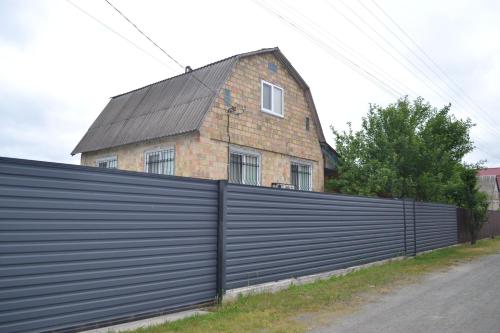 ein Haus hinter einem Zaun mit einem Gebäude dahinter in der Unterkunft Family & Relax Loft Lake House 