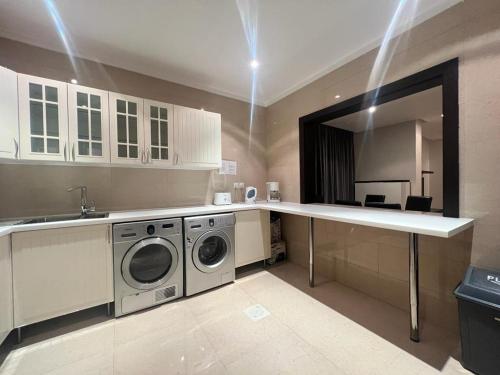 a kitchen with a sink and a washing machine at White Luxury Suite Hotel in Kuwait