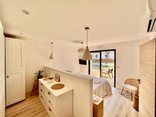 - une chambre blanche avec un lit et un bureau dans l'établissement La villa d’Hortense, à Labenne