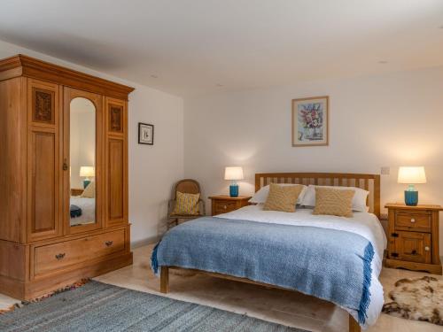 um quarto com uma cama e um espelho grande em Swallows Barn em Totnes