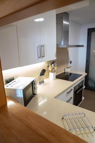 a kitchen with white cabinets and a counter top at Apartamentos Calpestabili in Altea