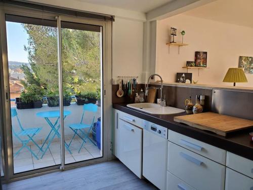 a kitchen with a sink and a sliding glass door at Lou beach home 75 m2 à 300 m de la plage avec vue mer in La Ciotat