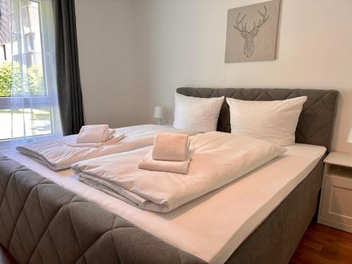 a large bed with two towels on top of it at Apartment BERGseetraum - Bergblick, neu renoviert, gemütlich, familienfreundlich in Schliersee