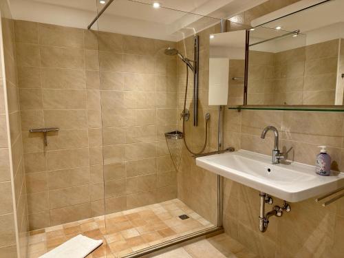 a bathroom with a sink and a shower at Apartment BERGseetraum - Bergblick, neu renoviert, gemütlich, familienfreundlich in Schliersee