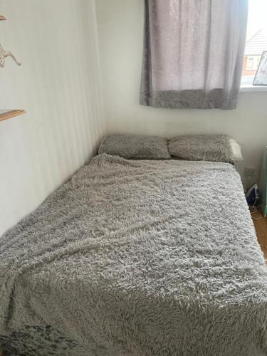 1 cama con edredón gris en un dormitorio en Ultimate Cozy Room, en Kirkstall