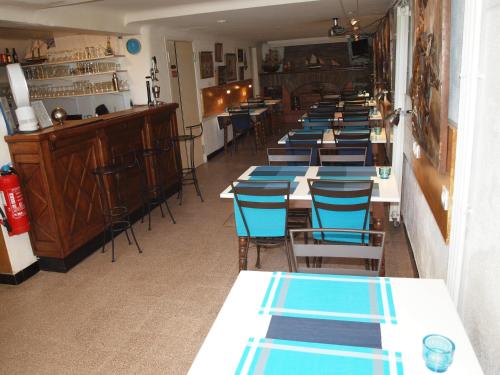une longue rangée de tables et de chaises dans un restaurant dans l'établissement Hôtel Restaurant - Villa Les Sirènes, à Argelès-sur-Mer