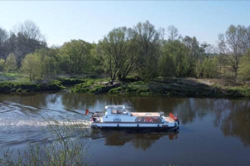 een witte boot op het water in een rivier bij River Yacht Age of Aquarius in Poznań