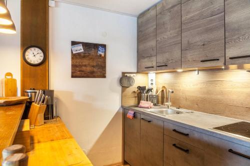 a kitchen with a sink and a clock on the wall at Haus Excelsior Top 31 in Seefeld in Tirol