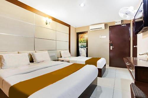 um quarto de hotel com duas camas e uma televisão em Sejati Hotel em Sitiawan
