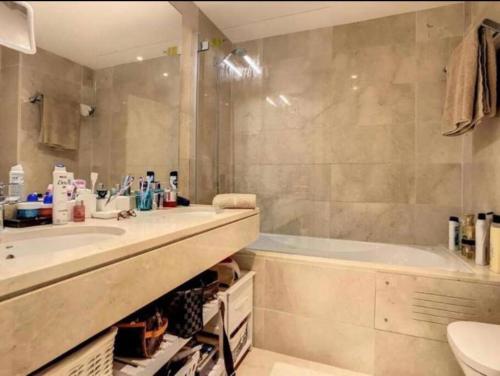 ein Badezimmer mit einer Badewanne, einem Waschbecken und einer Badewanne in der Unterkunft Appartement luxueux, piscine, padel et golf de Doña Julia in Bahia de Casares