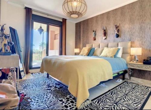 ein Schlafzimmer mit einem großen Bett und einem großen Fenster in der Unterkunft Appartement luxueux, piscine, padel et golf de Doña Julia in Bahia de Casares