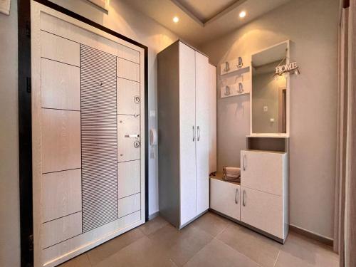 a kitchen with white cabinets and a refrigerator at Апартамент Чаролит / Apartment Charoite in Burgas City