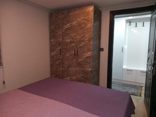 - une chambre avec un lit violet et une porte en verre dans l'établissement Han Apart, à Istanbul