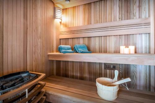 una sauna con paredes y estanterías de madera y un cubo en Chalet Arpitania - OVO Network, en La Clusaz