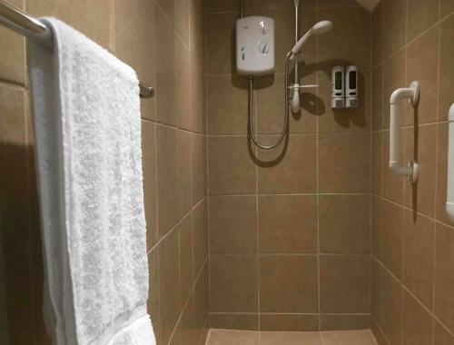 Un baño con ducha con cortina de ducha. en Plas Bach, en Haverfordwest