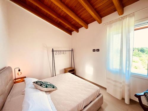 a bedroom with a bed and a large window at La Rocchetta B&B in Rocchetta