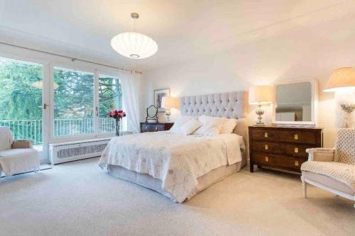 Un dormitorio con una cama grande y una ventana en Stunning Villa overlooking lake, en Le Châtelard-Montreux