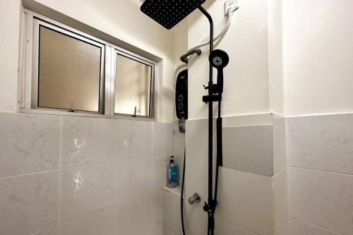 a shower in a bathroom with a window and a shower at Green-Scenery Suburban by Irdina's Homestay in Kampong Perimbun