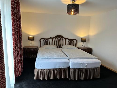 ein Schlafzimmer mit einem großen Bett mit zwei Nachttischen in der Unterkunft 1852 Landgasthof- Ferienwohnung in Elze