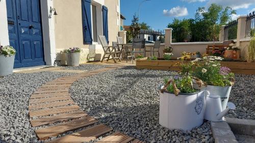a garden with potted plants and a house at For Me Formidable in LʼIsle-Jourdain