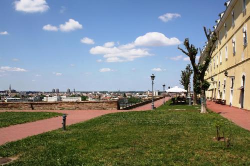 a park with a tree next to a building at Garni Hotel Leopold I in Novi Sad