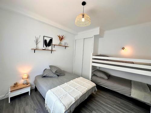 - une chambre blanche avec un lit et une table de nuit dans l'établissement Paradis - Hyper Centre, a deux pas de la Mer !, à Canet