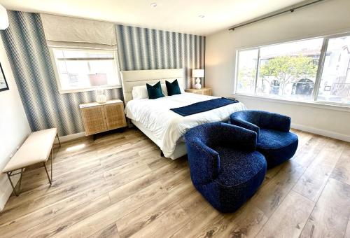 a bedroom with a bed and two blue chairs at AZUL on Avenida Del Mar (1/2 Mile to the PIER!) in San Clemente