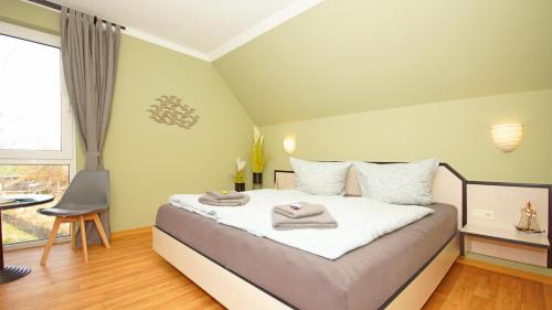 1 dormitorio con 1 cama con toallas en F-1010 Strandhaus Mönchgut Bed&Breakfast DZ 37 strandnah, inkl Frühstück en Lobbe