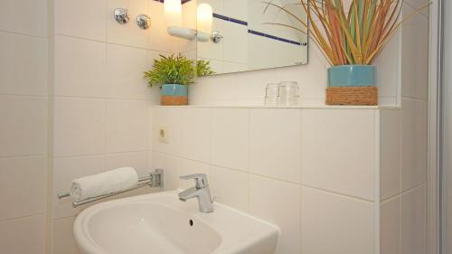 a bathroom with a sink and a mirror and plants at F-1010 Strandhaus Mönchgut Bed&Breakfast DZ 37 strandnah, inkl Frühstück in Lobbe