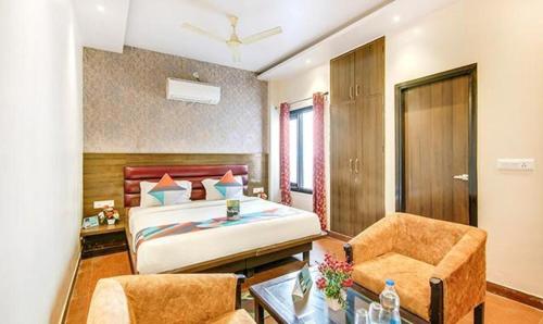 a bedroom with a bed and a desk and a chair at FabHotel The Gayatri Palace in Lucknow