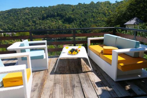 a balcony with two chairs and a table on a deck at Inas & Lemia Forrest Homes with Outdoor Swimming Pool in Bihać