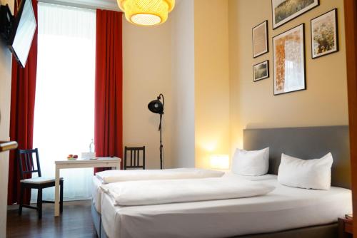 a hotel room with two beds and a window at Aparthotel Mitte in Dresden