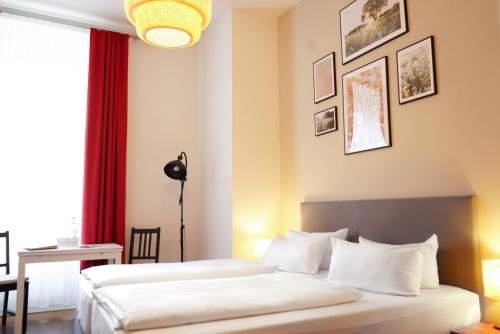 a bedroom with two beds and a red curtain at Aparthotel Mitte in Dresden