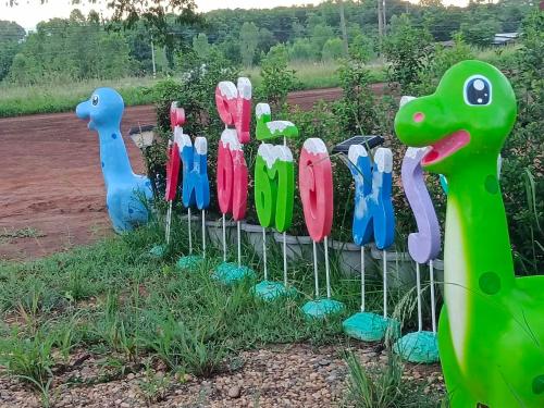 a row of colorful plastic animals in the grass at JUNPEN RESORT in Ban Hai Yong