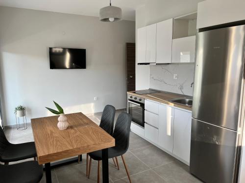 uma cozinha com uma mesa e cadeiras e um frigorífico em Aurora Apartments em Nea Vrasna