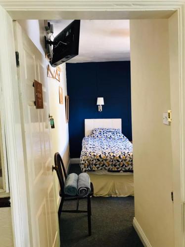 a bedroom with a bed with a blue wall at Wharfe View B&B in Burnsall