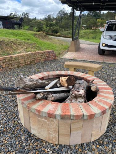 a fire pit with logs and sticks in it at Romántica Cabaña con vista a la ciudad, 10 min del Centro in Chiquinquirá