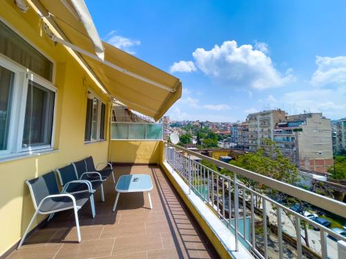 a balcony with chairs and a table on a building at City Plaza Apartments & Rooms in Thessaloniki