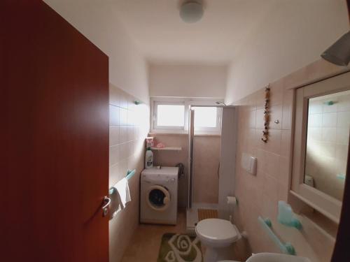 a bathroom with a toilet and a sink at Appartamento MaRi con piscina in Torre Lapillo