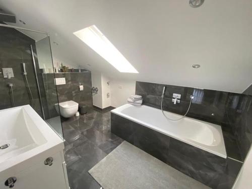 uma casa de banho com uma banheira, um WC e um lavatório. em Ferienwohnung im Allgäu em Bernbeuren