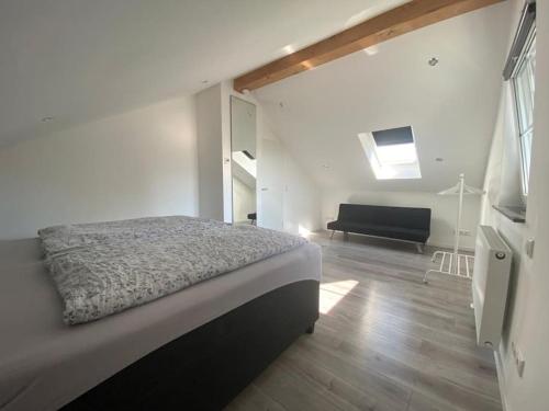 um quarto com uma cama e um sofá num quarto em Ferienwohnung im Allgäu em Bernbeuren